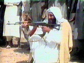 写真・図版 : 2001年６月にクウェート紙が入手した、銃を構えるオサマ・ビンラディン容疑者の映像＝ロイター
