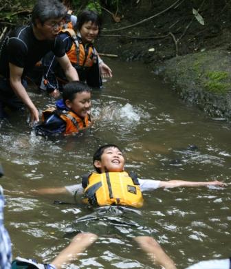 写真・図版 : 北海道栗山町の廃校を拠点に開かれた自然体験プログラム。ライフジャケットをつけて川泳ぎをした（本文とは直接関係ありません）＝2010年６月、及川綾子撮影