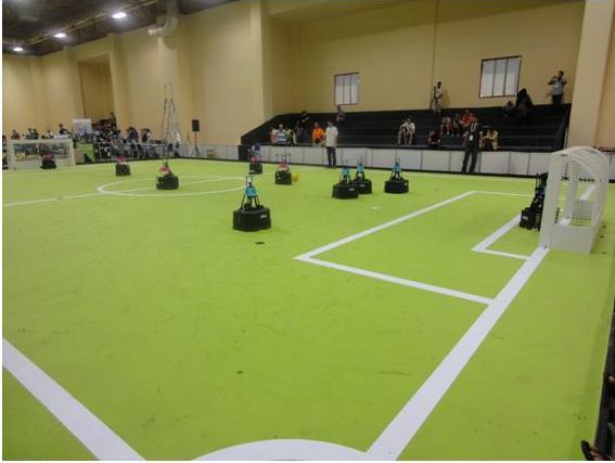 写真・図版 : RoboCup中型ロボットリーグのフィールド。これは、車輪型ロボットのチームの対戦。ロボットは完全自律型で人間は一切介入しない＝筆者撮影