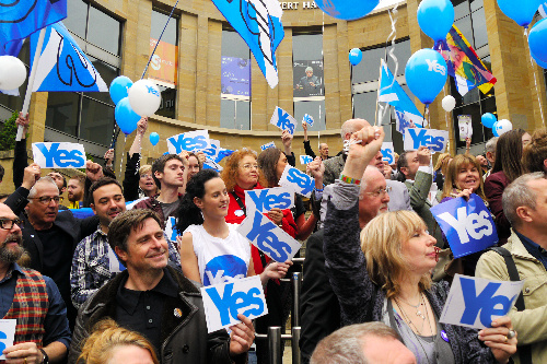 写真・図版 : スコットランドの独立を問う住民投票前日、最大都市グラスゴーで独立支持派が「イエス」と書かれたカードを手に気勢を上げた＝2014年9月17日