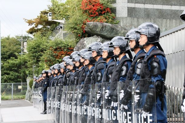 野村悟容疑者の家宅捜索で自宅前に並ぶ機動隊員ら＝１０月６日、北九州市
