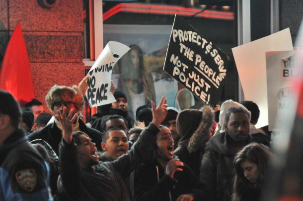 抗議する若者たち。「市民を守り、奉仕してくれ」と書かれたプラカードが見える＝４日深夜、米ニューヨークのタイムズスクエア