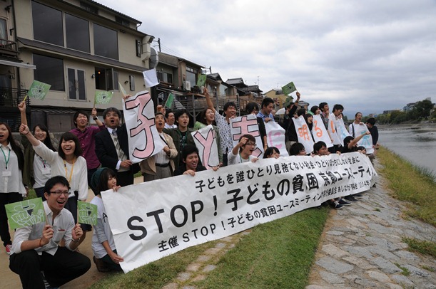 「子どもの貧困」をテーマにした集会のあと、鴨川の河川敷で通行人にアピールする大学生ら＝2014年10月、京都市中京区