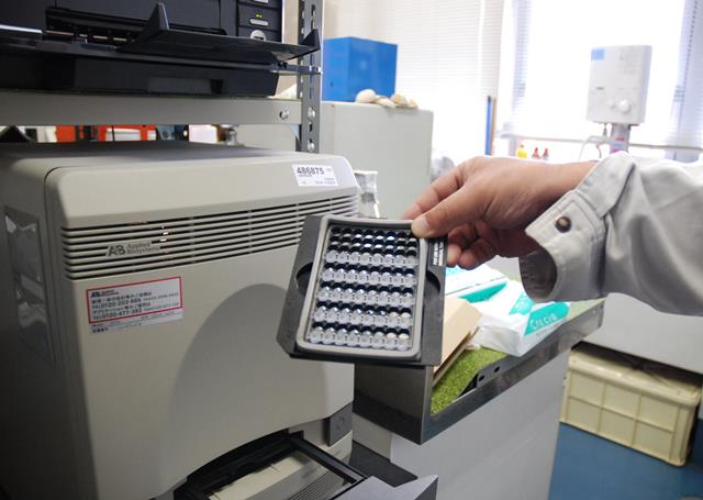 写真・図版 : PCRは国内でも広く使われている。写真は、新型インフルエンザ確認のために検体の遺伝子入りチューブを機械に入れるところ＝辻外記子撮影 