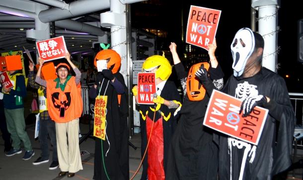 写真・図版 : ハロウィーンの仮装をして安保法反対を訴える人たちも＝北九州市のＪＲ小倉駅前