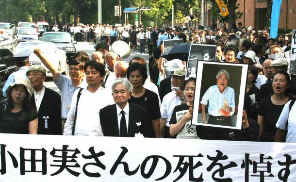 小田実さんの遺影と鶴見俊輔さんを先頭に追悼デモがおこなわれた＝2007年8月、東京都港区
