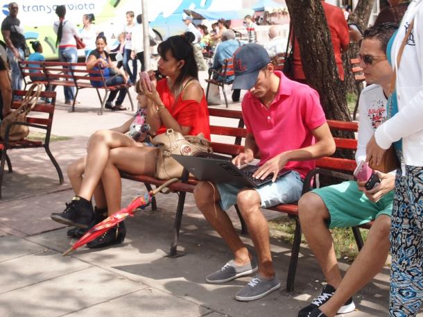 写真・図版 : ベンチでパソコンやスマホを操作する市民たち＝サンタクララで　撮影・筆者