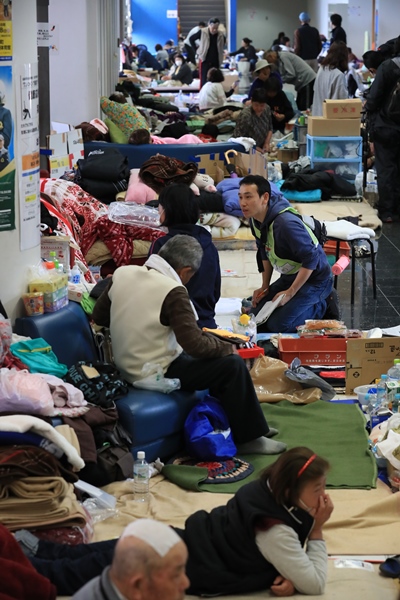 避難所になっている総合体育館でアリーナに入れず、廊下で避難生活を送る人たち＝2016年4月24日、熊本県益城町