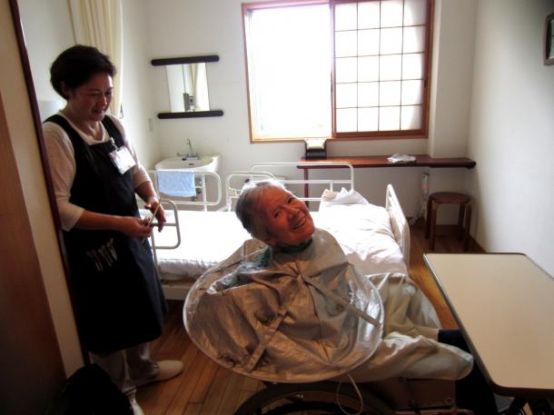 写真・図版 : 「すき」が似合う女性、鳥取市の野の花診療所の病室で。理容、「すっきりしましたよ」＝2016年2月