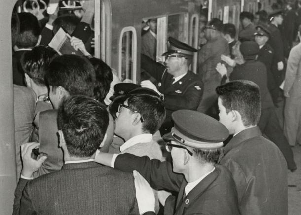 写真・図版 : かつては駅員さんなどが乗客を車内に押し込む「押し屋」が大活躍していた＝1965年の新宿駅