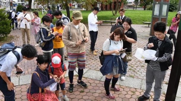 写真・図版 : ポケモンを探しながら交流するファンたち＝北海道江別市