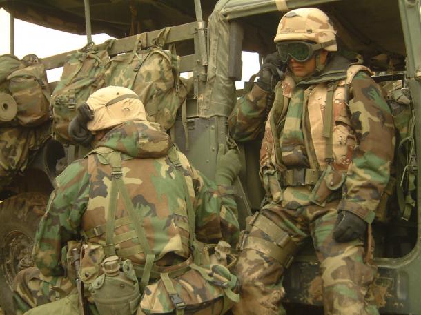 イラク軍から移動中に突然襲撃を受け、無線で近隣の部隊の状況を確認する米海兵隊員＝2003年4月、イラク中部ナーシリア