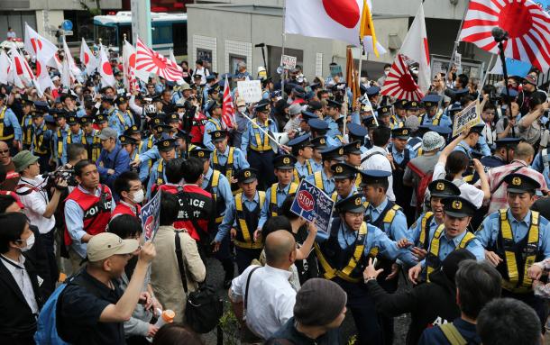 写真・図版 : 衝突を阻止しようと、警察官が列を作り、デモ隊と反対派の人たちを隔てていた＝6月5日、東京・渋谷