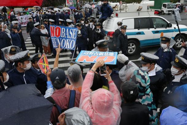北部訓練場返還式が行われる会場へと向かう交差点で抗議活動をする人たち＝２２日午後３時５０分、沖縄県名護市