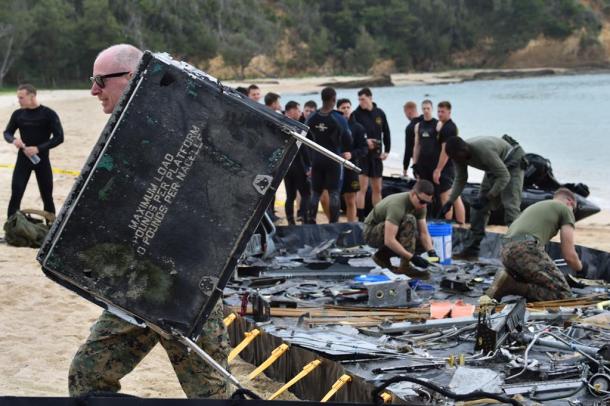 写真・図版 : オスプレイが大破した現場付近で、部品回収作業をする米軍関係者＝2016年12月22日、沖縄県名護市安部