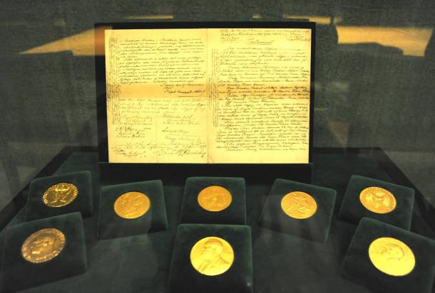 写真・図版 : ストックホルムのノーベル財団本部に展示されているアルフレッド・ノーベルの遺言書とメダル