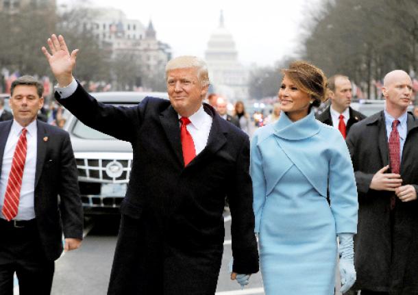 写真・図版 : ワシントンで1月20日、就任パレードで手を振るトランプ米大統領とメラニア夫人＝ロイター