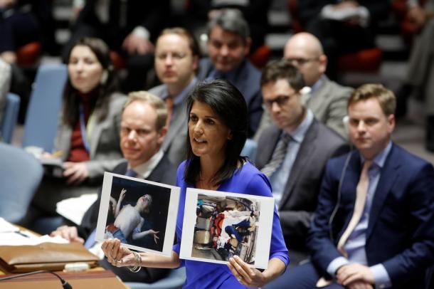 国連安全保障理事会の緊急会合で、幼児が横たわる写真を掲げて「行動」を求める米国のヘイリー国連大使＝国連提供 UN PhotoEvan Sc