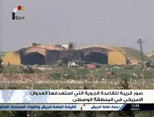 写真・図版 : 米軍の攻撃を受けたシリア中部ホムスの近郊にある空軍基地の写真。4月7日、シリア国営テレビで放送された＝ロイター