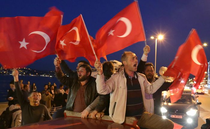 写真・図版 : 投票終了後、改憲賛成の勝利を確信し、トルコ国旗を手に車から乗り出す賛成派の人たち＝4月16日