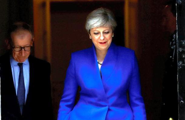 ロンドンで6月9日、総選挙の結果を受けて、バッキンガム宮殿に向かうため首相官邸を出るメイ首相（右）＝ロイター 