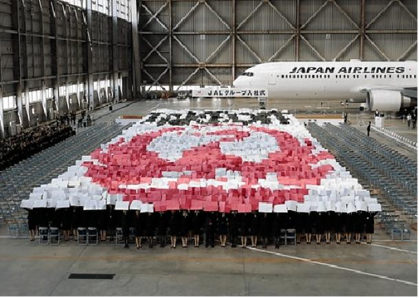 写真・図版 : 4月一斉入社は日本企業の特徴。日本航空グループの今年の入社式には1672人が参加し、ツルの絵文字を描き出した=同社HPより