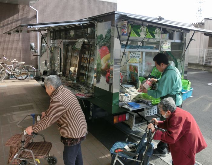 写真・図版 : 高齢者住宅に駐車した移動販売車で買い物するお年寄りたち＝前橋市元総社町