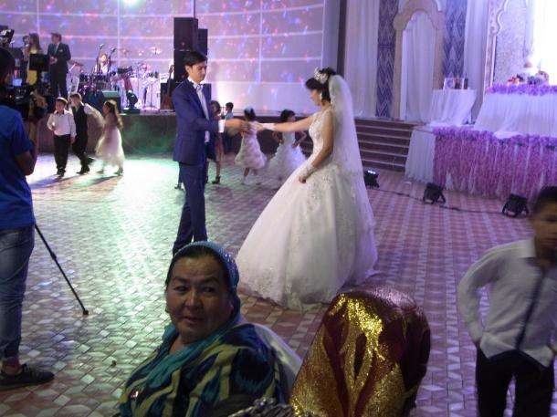 写真・図版 : 大勢の参列者を前に結婚式で踊る新郎と新婦（サマルカンドで）＝撮影・筆者