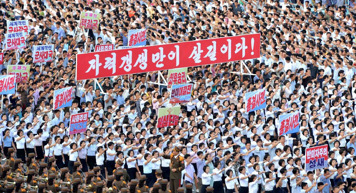 写真・図版 : 平壌で８月９日、国連安保理事会の制裁決議に反対する北朝鮮の政府声明を支持する集会が開かれ、プラカードを掲げて行進する市民ら。朝鮮中央通信が配信した＝朝鮮通信