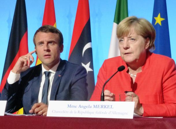 写真・図版 : 難民問題での会議を終えて記者会見にのぞんだ仏マクロン大統領（左）と独メルケル首相＝8月28日、パリ