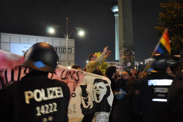 写真・図版 : 新興右翼政党「ドイツのための選択肢（AfD）」が躍進を祝う集会会場に向かって、抗議の声を上げる人々＝9月24日、ベルリン
