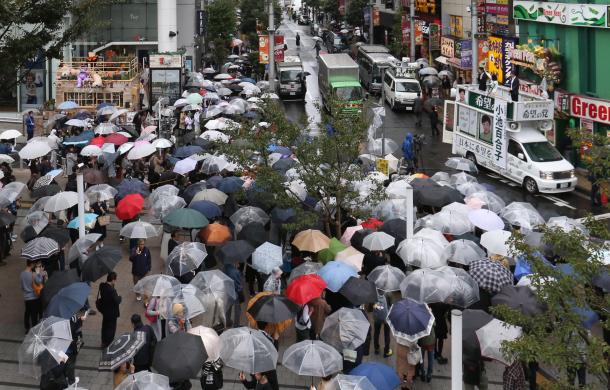 雨の中、街頭演説を聞く有権者たち＝10月15日、東京都内（選挙カーなどにモザイクをかけています）