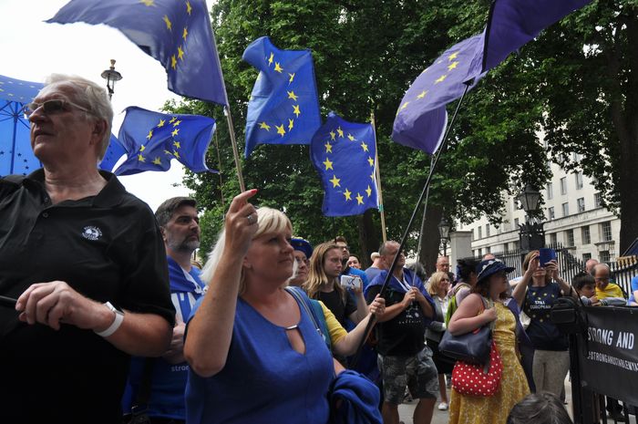 写真・図版 : 英首相官邸の前で、欧州旗を振りながらＥＵ離脱反対を訴える人たち＝6月23日、ロンドン