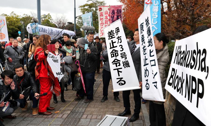 写真・図版 : 運転差し止めの仮処分決定が出され、旗を掲げる弁護士ら＝12月13日、広島市