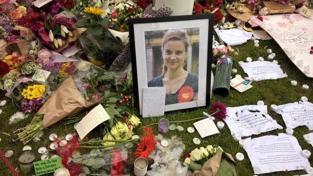 写真・図版 : 殺害されたコックス議員の写真の周りに、たくさんの人が追悼の花束を置いた＝2016年6月、パーラメント広場