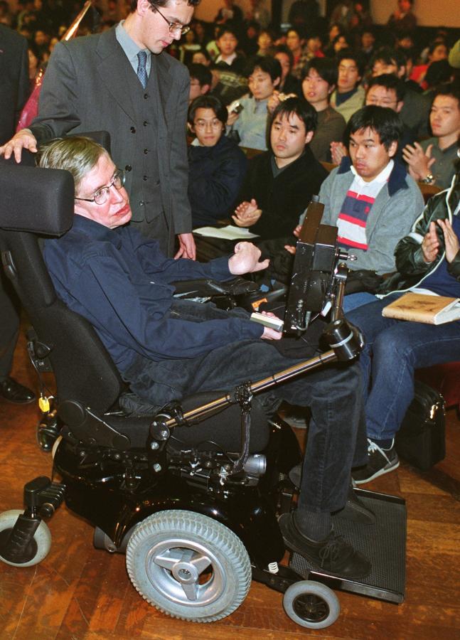 写真・図版 : 2001年、東京大学の安田講堂で講演し、学生たちに拍手で送られるホーキング博士