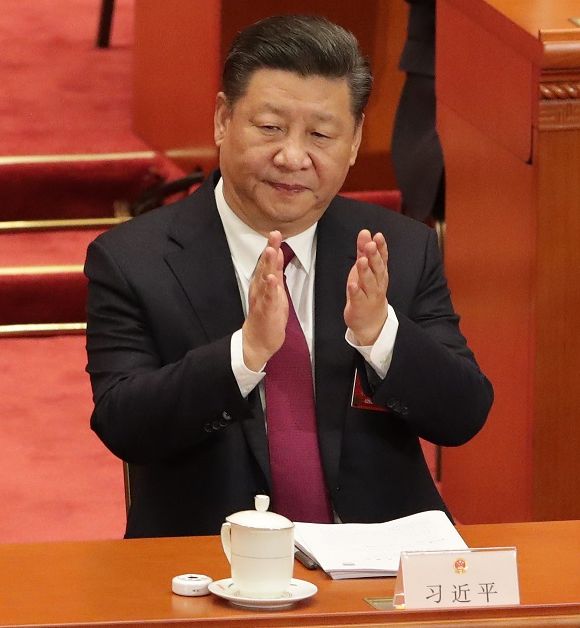 写真・図版 : 全人代が開幕し、拍手をする習近平国家主席＝3月５日、中国・北京