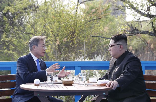 写真・図版 : ベンチに座って話し込む韓国の文在寅大統領（左）と北朝鮮の金正恩委員長（右）＝4月27日、板門店