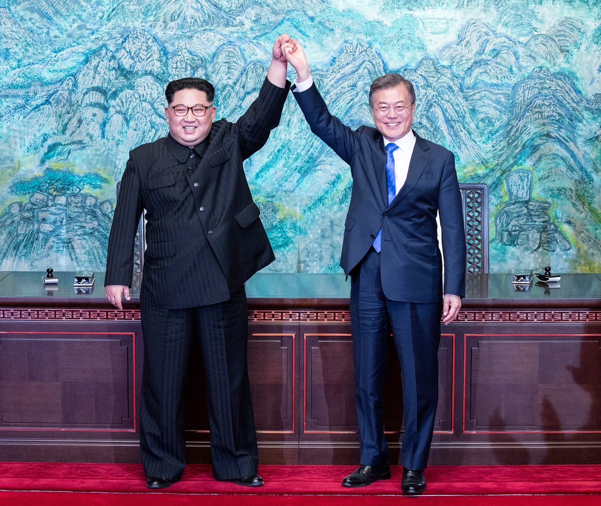 写真・図版 : 共同宣言に署名をした後、手を取り合って喜ぶ北朝鮮の金正恩委員長（左）と韓国の文在寅大統領（右）＝2018年4月27日、韓国共同写真記者団撮影