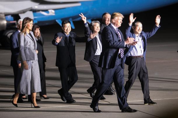 北朝鮮から解放されて帰国し、喜びを体で表す牧師のキム・ドンチョル氏（右端）、平壌科学技術大運営関係者のキム・ハクソン氏（右から４人目）、同大教授のキム・サンドク氏（右から５番目）。トランプ大統領らが出迎えた＝２０１８年５月１０日、米ワシントン郊外のアンドルーズ空軍基地、ランハム裕子撮影