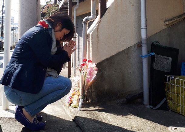 目黒の5歳児虐待死事件の発覚後、亡くなった船戸結愛ちゃんが暮らしていたアパート前に花を手向ける人が相次いだ＝2018年3月4日、東京都目黒区