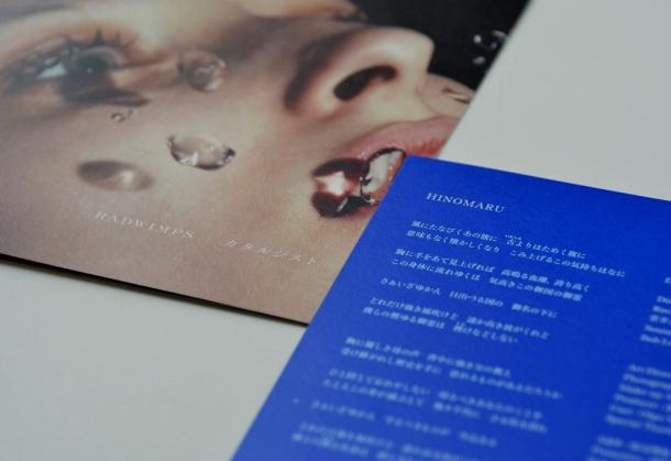RADWIMPSの新曲「HINOMARU」の歌詞カード(右下)と、同曲を収録したCDのジャケット