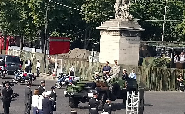 写真・図版 : 軍用車に乗ってルコワントル参謀総長とシャンゼリゼ大通りをくだるマクロン大統領＝2018年7月14日、筆者撮影