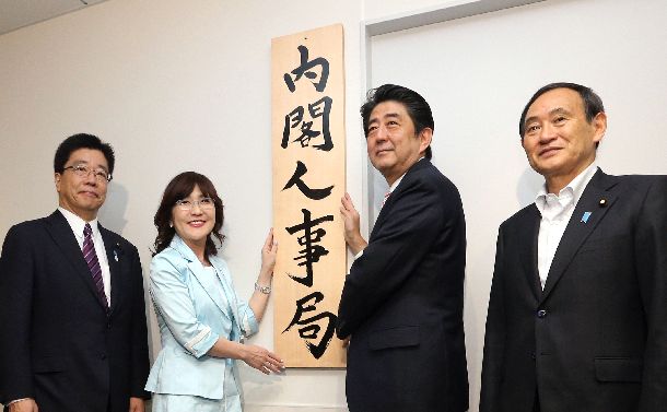 写真・図版 : 内閣人事局が発足、看板かけをする安倍晋三首相（右から２人目）ら＝2014年5月30日