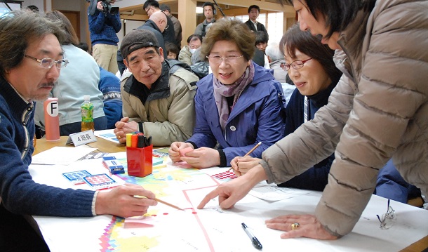 写真・図版 : ハザードマップをもとに住民らが避難経路などを話し合う津波避難のワークショップ＝2013年3月、富山県射水市