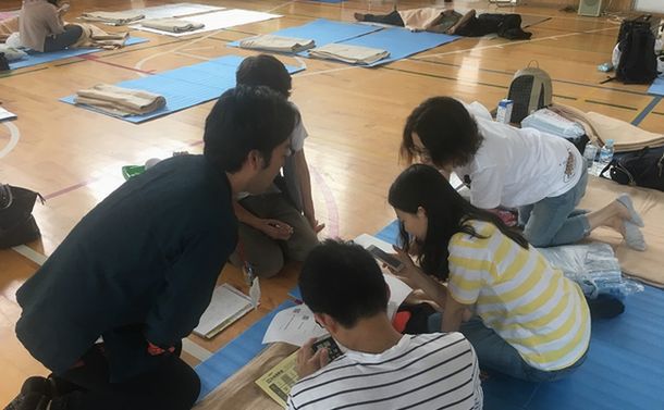 写真・図版 : 避難所の豊川南小学校で住宅のひび割れについて相談をうけるスタッフ＝箕面市（筆者撮影）