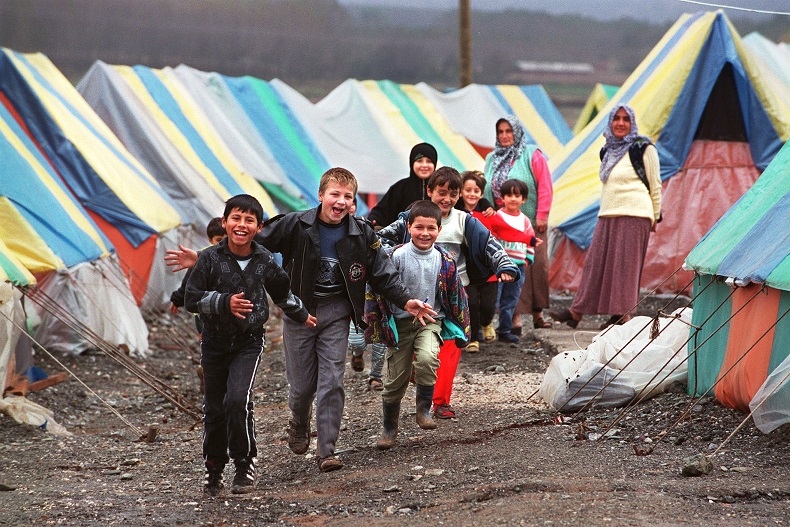 写真・図版 : 被災地のテント村で走り回る子どもたち＝1999年10月30日、トルコ西部アダパザルで 