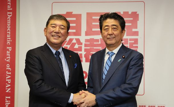 自民党総裁選の記者会見で握手する安倍晋三首相（右）と石破茂氏=2018年9月10日