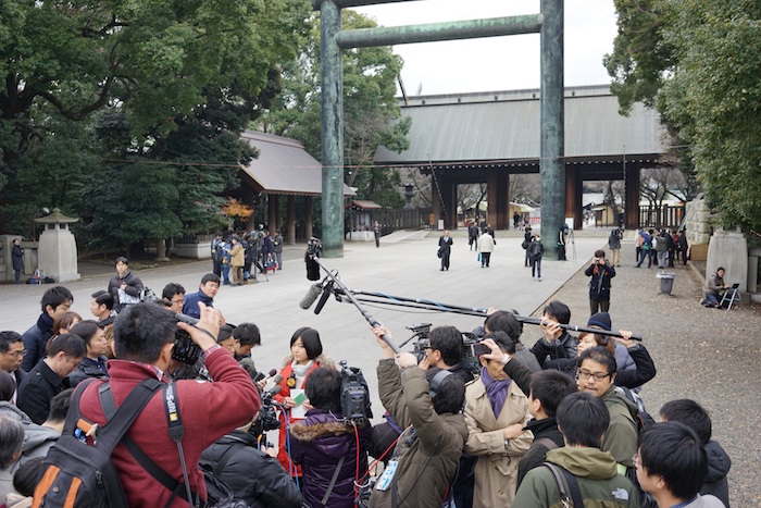 写真・図版 : 安倍首相の靖国神社参拝を中継後、日本メディアに取材される＝2013年12月