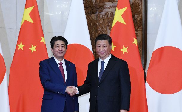 日中首脳会談を前に握手する安倍晋三首相（左）と中国の習近平国家主席＝2018年10月26日、北京の釣魚台迎賓館